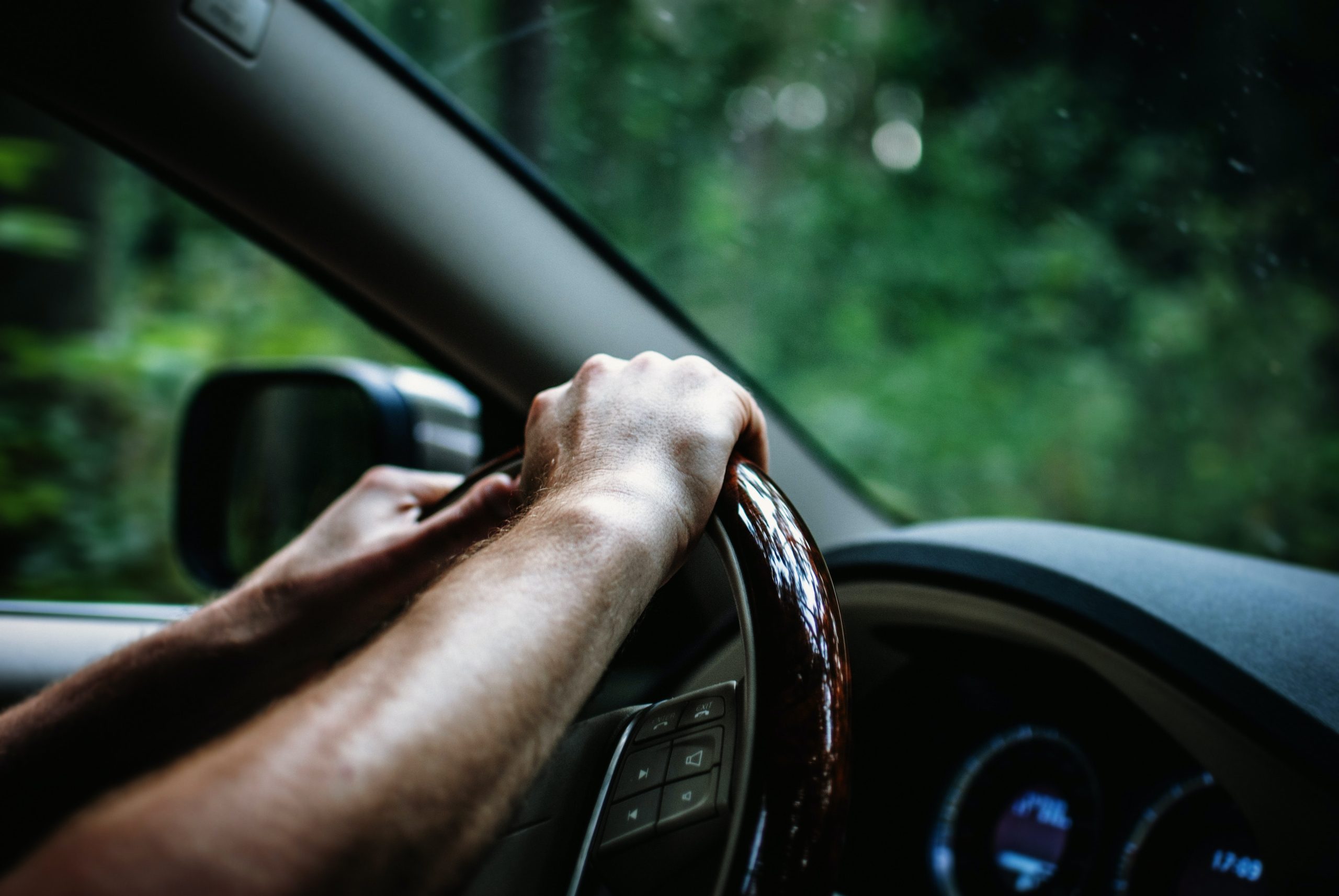 person having both hands on the steering wheel