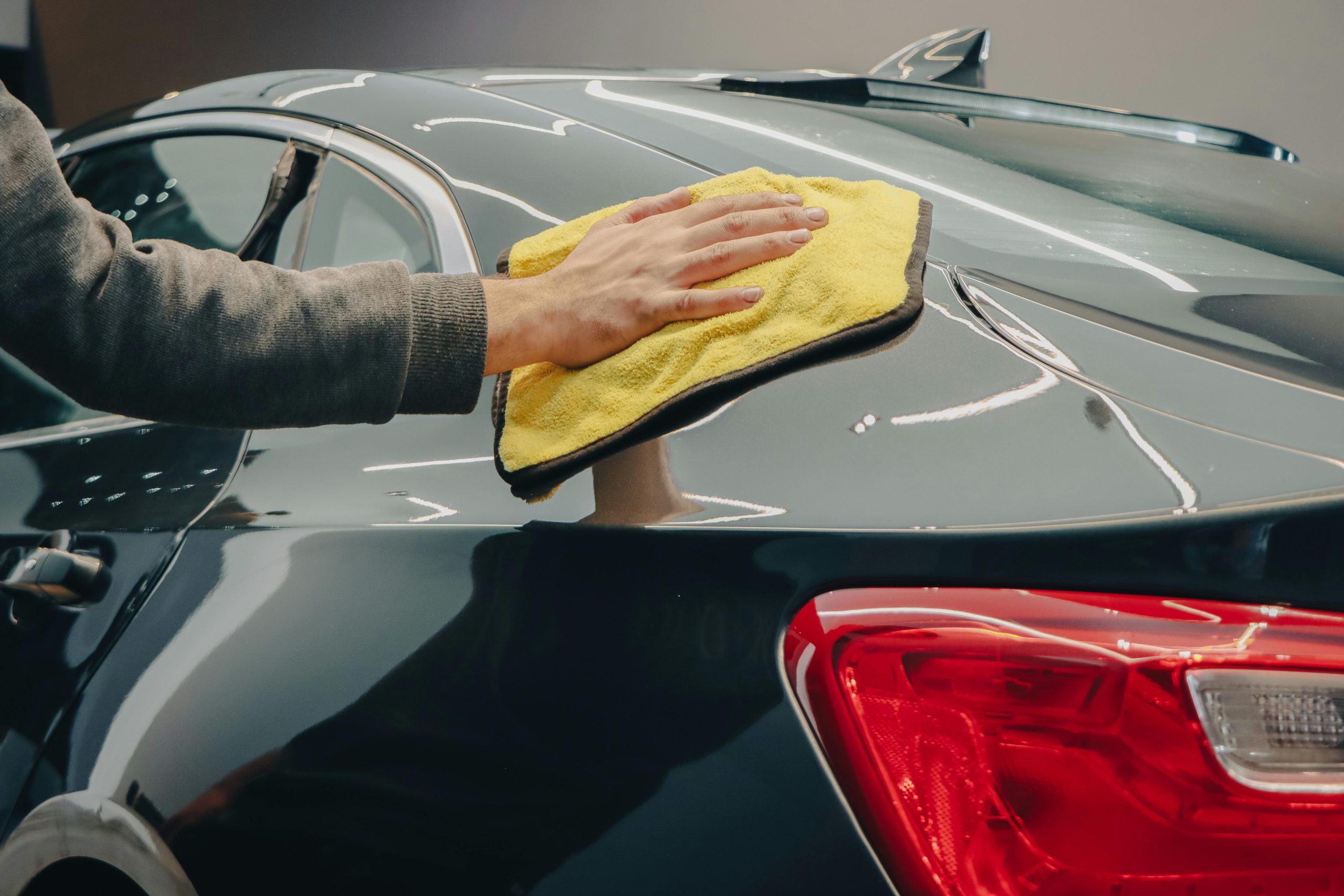 mackins technician using a yellow rag to buff out a scratch