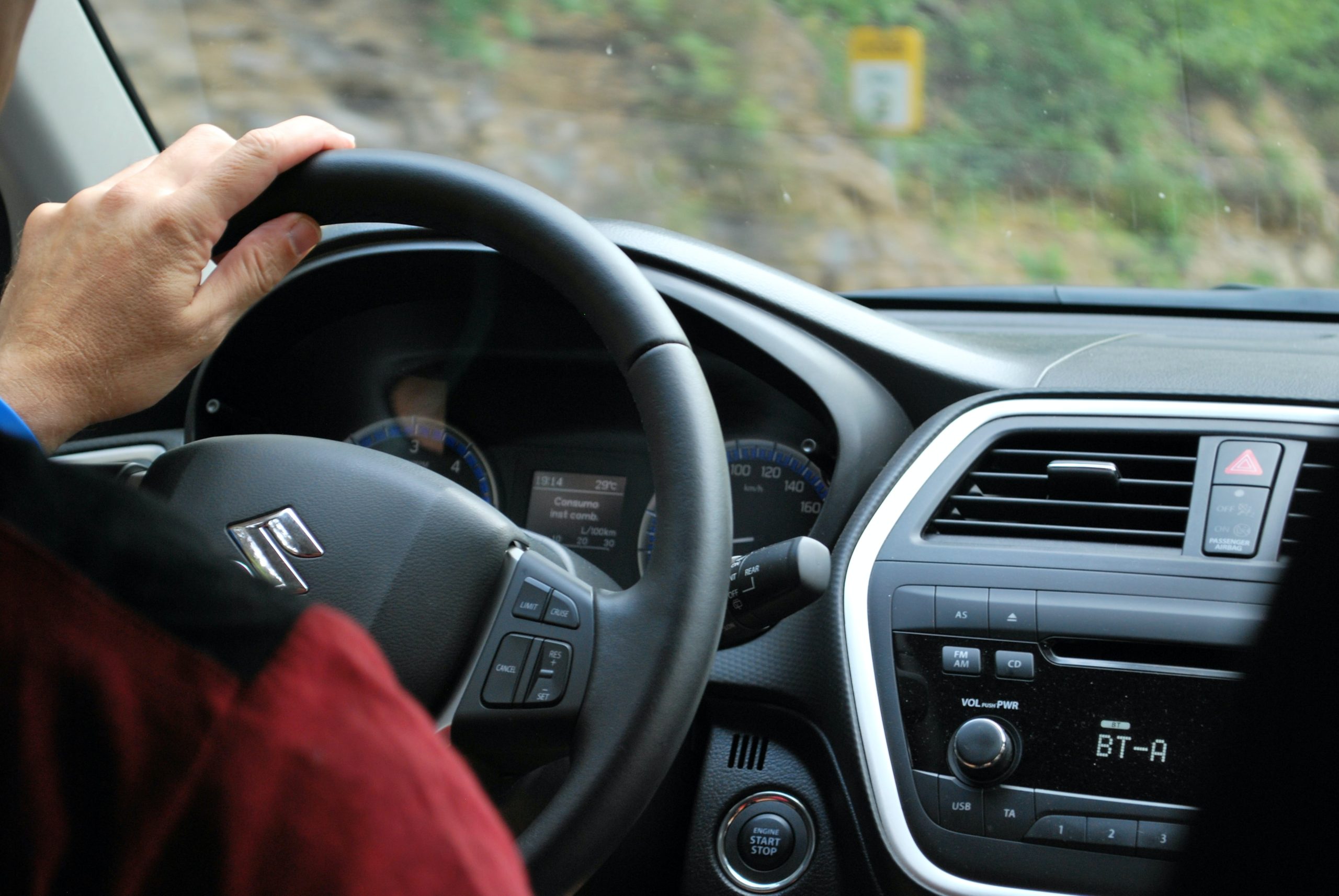 person with hand on the steering wheel 