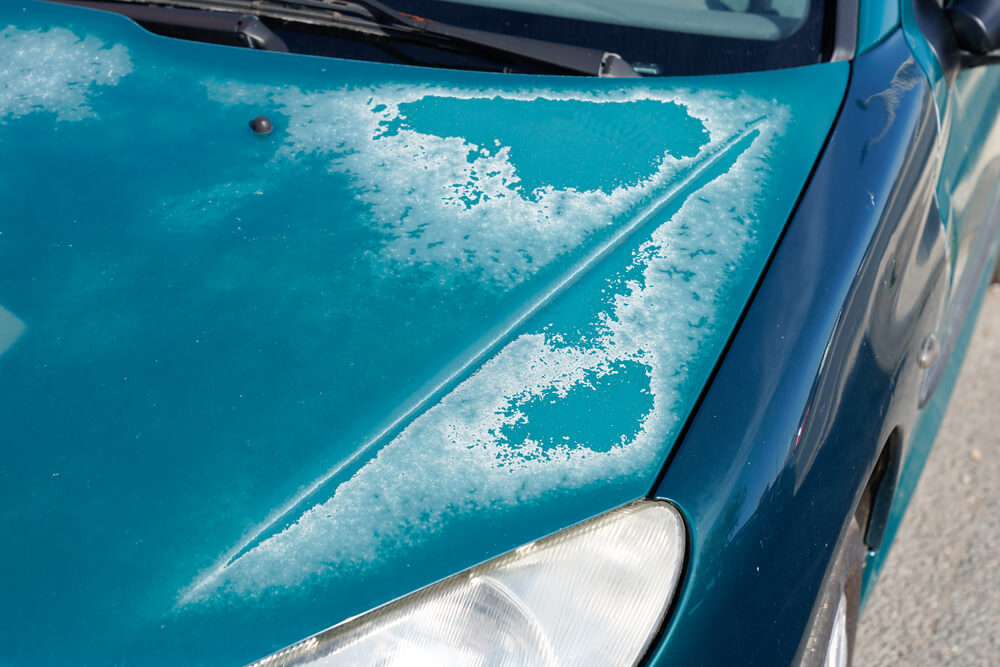 Hood of an old car with fading paint