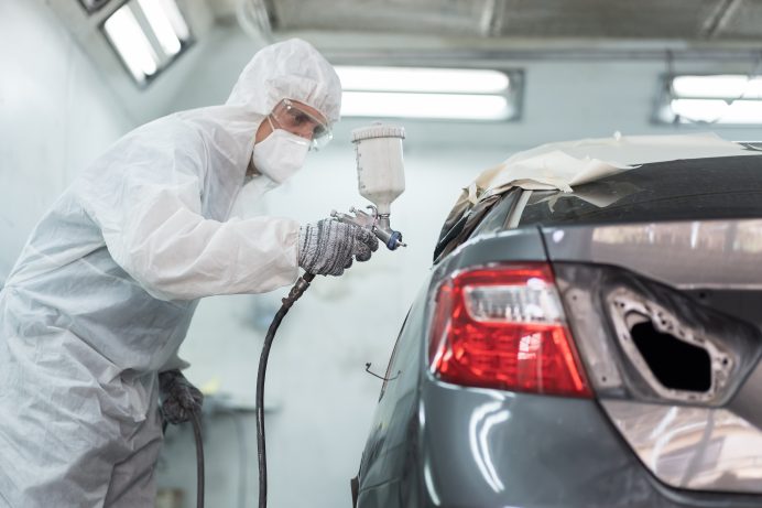 technician spray painting a car